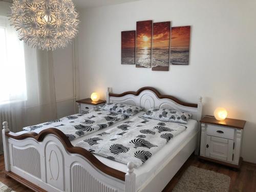 弗伦斯堡Ferienwohnung "Am Nordertor"的卧室配有一张白色床、两张桌子和吊灯。