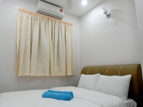 太平Taiping Cozy Homestay II的一间卧室配有一张带蓝色毛巾的床
