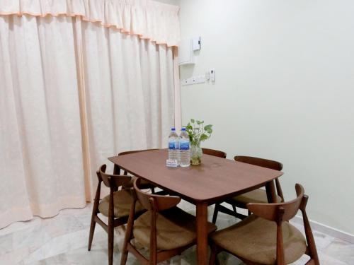 太平Taiping Cozy Homestay II的一张桌子、两瓶水和两把椅子