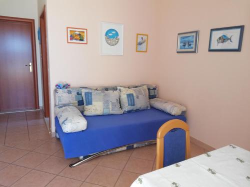 普利莫顿Apartmani Marija的客房设有蓝色的沙发,上面有枕头