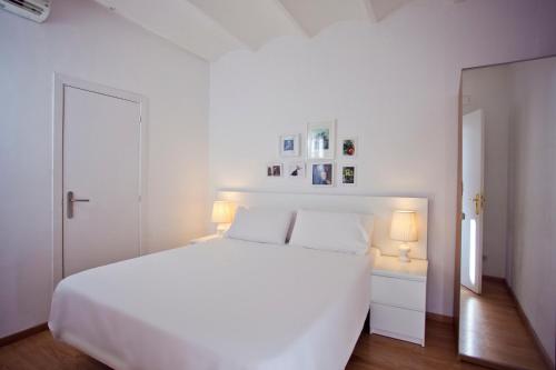 巴塞罗那兰巴拉斯公寓式酒店的白色卧室配有白色的床和两盏灯。