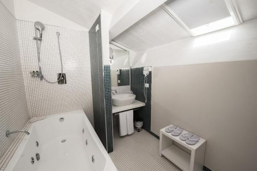 罗迪-加尔加尼科精英15号大厦旅馆的白色的浴室设有浴缸和水槽。