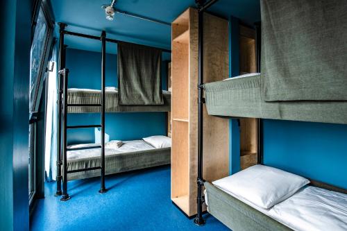 瓦尔内明德DOCK INN Hostel Warnemünde的蓝色墙壁的客房内设有两张双层床。
