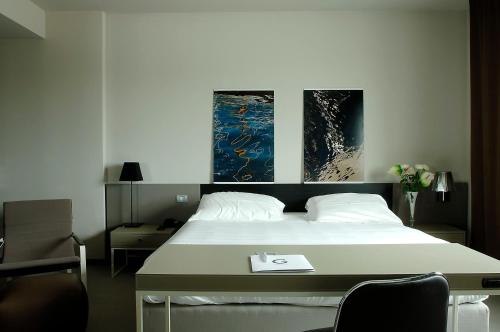 奥西莫G Hotel Ancona的卧室配有一张壁画和两张画的床铺。