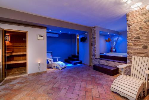 里米尼索尔米奥酒店的蓝色的客房设有浴缸、沙发和椅子