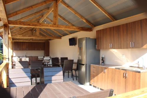 桑德雷什Gostevoi dom u Timura的一间带木制橱柜的厨房和一个带桌子的用餐区