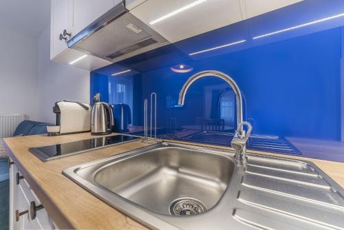 亚斯塔尔尼亚Apartamenty Draga的厨房设有水槽和蓝色的墙壁