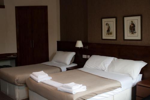 爱丁堡Edinburgh House Hotel的两张位于酒店客房的床,配有毛巾