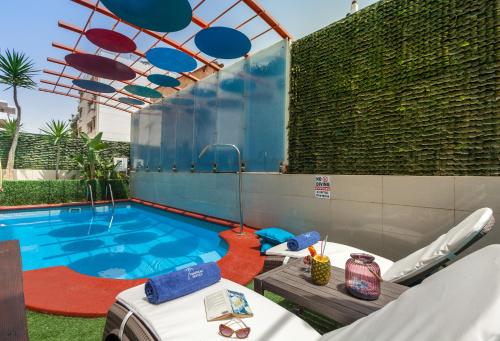 雅典热带酒店的游泳池旁设有桌椅