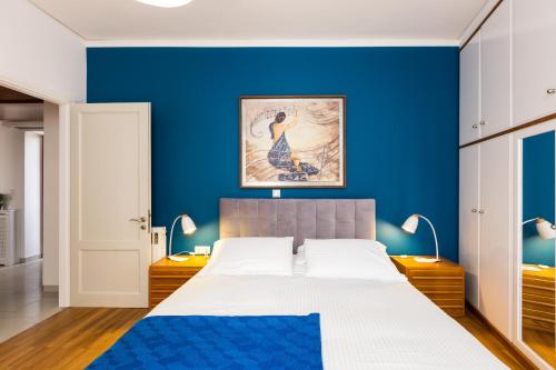 干尼亚La Vita Moderna的一间蓝色卧室,配有一张床和两盏灯