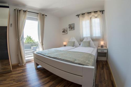 法扎纳Apartments Mojeljeto的白色的卧室设有一张大床和一个窗户