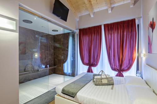 Montechiaro D'acqui特奴塔瓦尔多索酒店的一间卧室配有床和一个带红色窗帘的浴缸