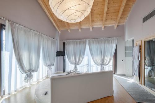Montechiaro D'acqui特奴塔瓦尔多索酒店的大型白色客房,设有窗户和白色大沙发