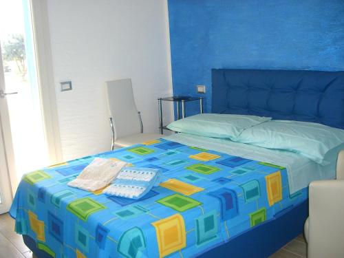 皮希纳斯S'Olivariu Village Affittacamere的一间卧室配有一张蓝色和黄色的床罩