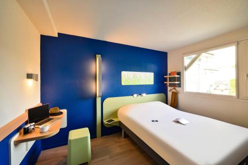 尚贝里尚贝里中心都市宜必思快捷酒店 的卧室配有白色的床和蓝色的墙壁