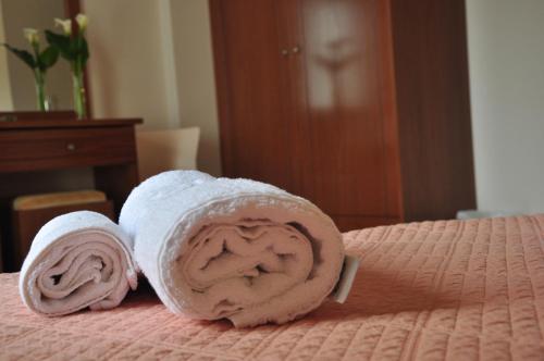 古卡斯特隆Ostria Hotel的两条滚毛巾(放置在床上)