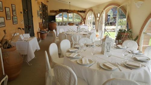 加沃拉诺La Locanda della Vecchia Hosteria的用餐室配有白色的桌子和白色的椅子