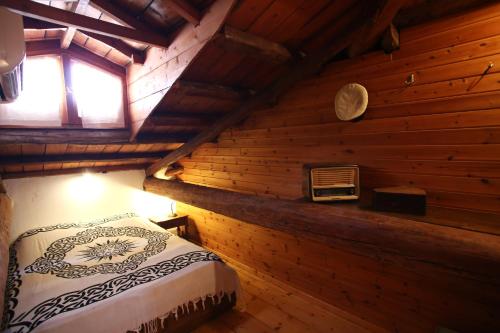 加拉希德松Traditional House的小木屋内一间卧室,配有一张床