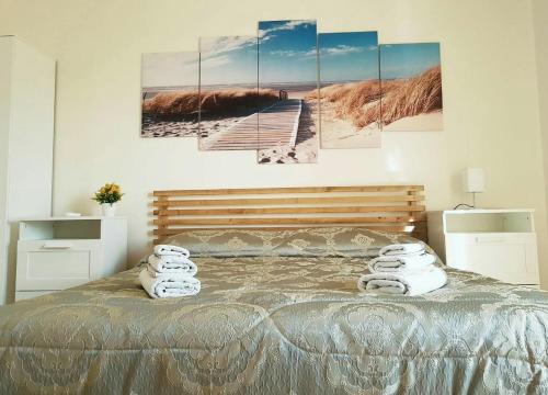 Casola di Napoli伊尔里弗吉奥苏德格尔非公寓的卧室配有一张壁挂着四幅画作的床