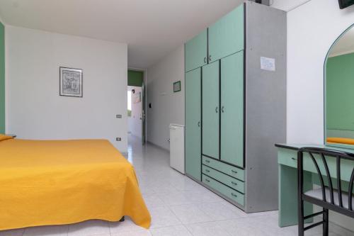 奥尔贝泰洛迷你酒店的一间卧室配有黄色的床和绿色的橱柜