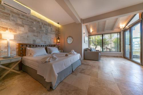 基尼拉Agorastos Suites的一间卧室设有一张大床和石墙