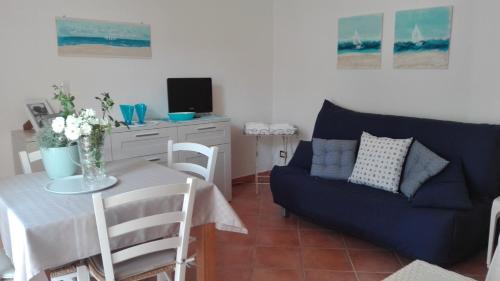 斯库索港Le Caravelle的客厅配有桌子和蓝色沙发