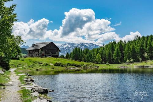 MonnoRIFUGIO AL LAGO DEL MORTIROLO in inverno raggiungibile solo a piedi的湖畔小山上的房屋