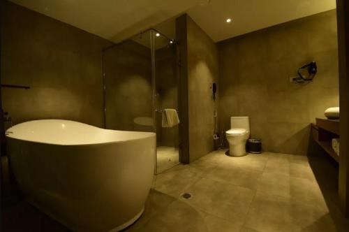 古瓦哈提Kiranshree Grand的带浴缸、淋浴和卫生间的浴室