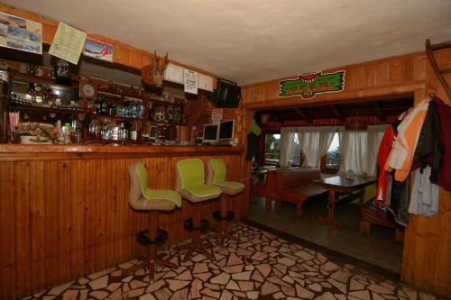 彼得罗沙尼Cabana la Razvan的一间酒吧,在房间内摆放着绿色椅子