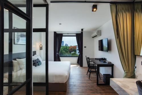 曼谷东方遗产公寓的配有一张床和一张书桌的酒店客房