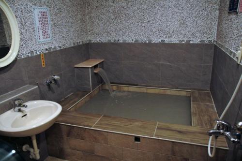 白河清秀旅社的浴室配有带水槽和水槽的浴缸。