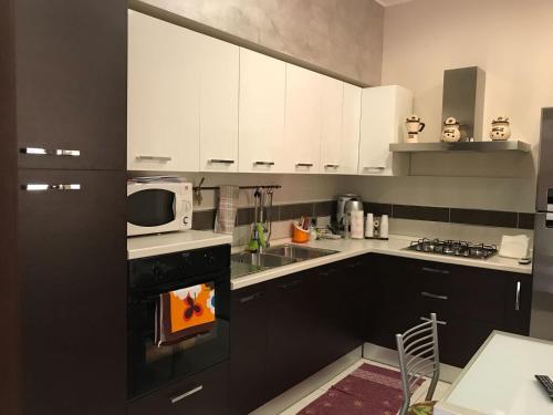 阿沃拉Casa Angela的厨房配有白色橱柜和炉灶烤箱。