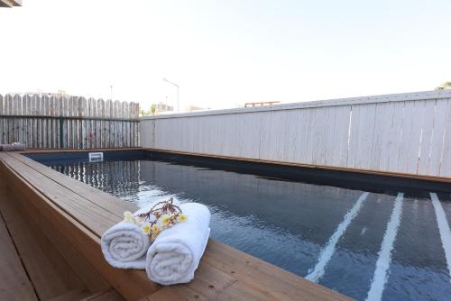 埃拉特艾姆达尔假日公寓的木制甲板上带毛巾的水池