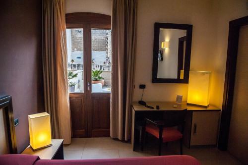 法维尼亚纳伊尔波迪克酒店的一间酒店客房,配有书桌和一个带镜子的门