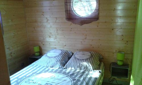 Cournonterralroulotte的小房间设有床和窗户