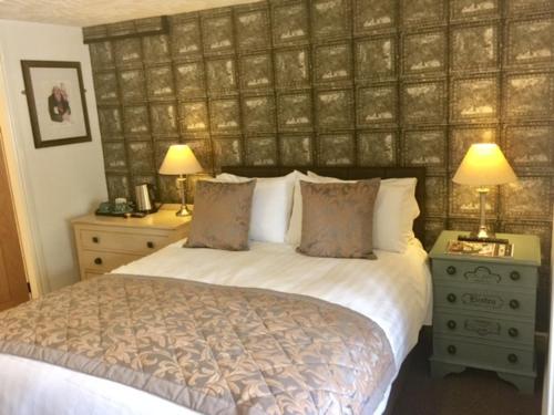 南特威奇The Swan Inn的一间卧室配有一张带两盏灯和两个床头柜的床