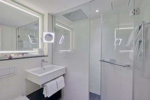 温特图尔索莱尔科隆酒店的白色的浴室设有水槽和淋浴。