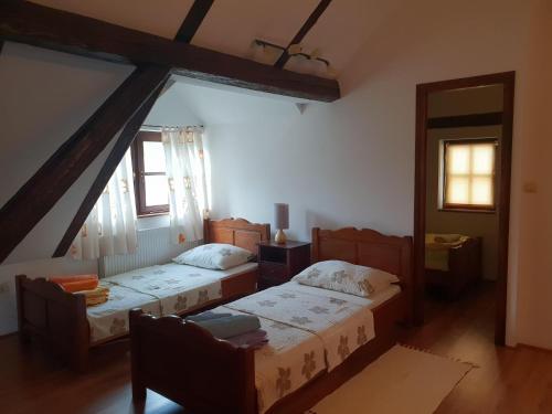 MiljanaSeoski turizam Sumak的一间卧室设有两张床和两个窗户。