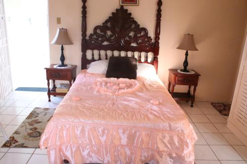 欧丘里欧Country Manor Apartments的一间卧室配有一张带粉红色棉被的床