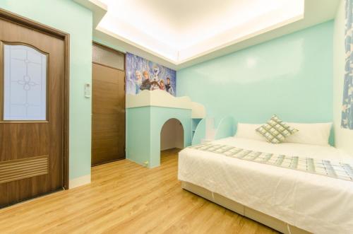 冬山乡蛋蛋民宿的一间卧室配有一张床,墙上挂着绘画作品