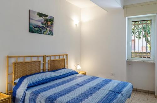 费尔莱恩Appartamento Anna的一间卧室配有一张带蓝色条纹棉被的床