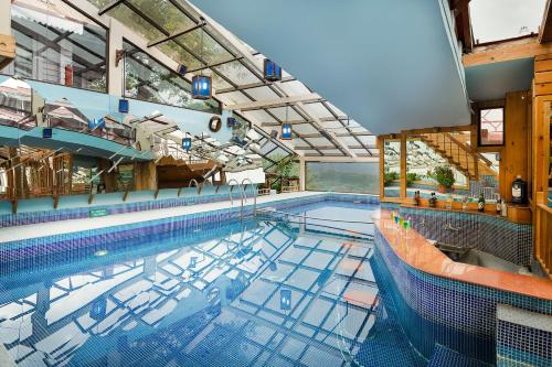 西姆拉The Chalets Naldehra的大型室内游泳池,带大型泳池景