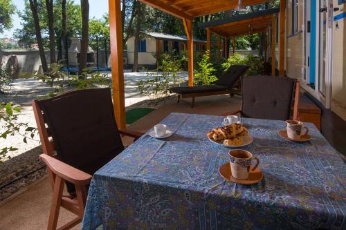 班约勒Mobile home - Kamp Olga的一张带杯子的蓝色桌子和盘子上的食物