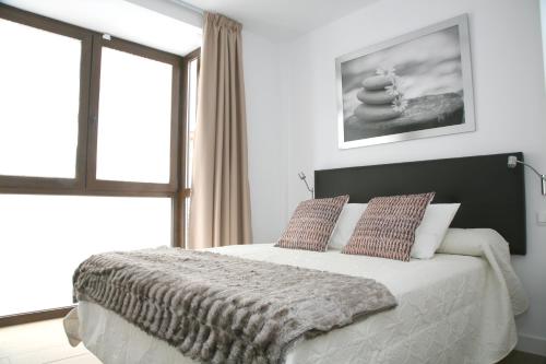 内尔哈Apartamentos Balcón de Nerja - Adults Only的一间卧室设有一张大床和一个窗户。