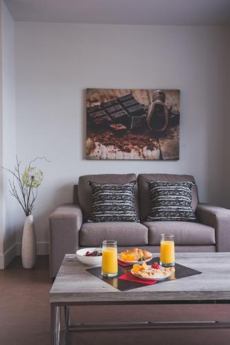 Ville-MarieLes suites de la chocolaterie的客厅配有沙发和带橙汁的桌子。