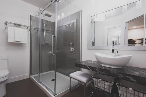 Ville-MarieLes suites de la chocolaterie的一间带玻璃淋浴和水槽的浴室