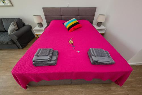 诺瓦利娅Villa Bramasole Lun的粉红色的桌子上挂着粉红色的毯子