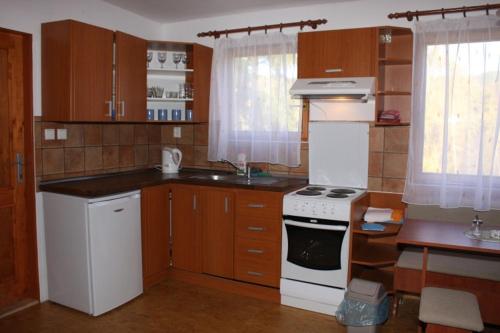 NalžoviceChaty u Toma Slapy的厨房配有木制橱柜和白色炉灶烤箱。