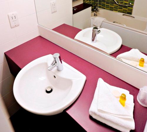 拉夫堡力推连接酒店的浴室设有白色水槽和镜子