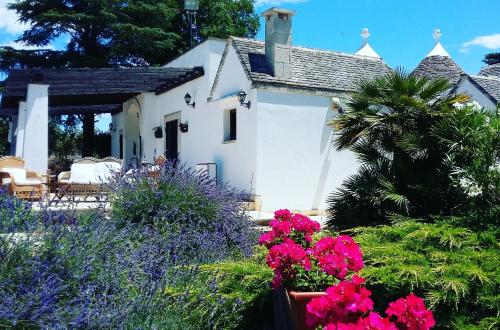 马丁纳弗兰卡Dimora nei Trulli的花园中花卉白色房子
